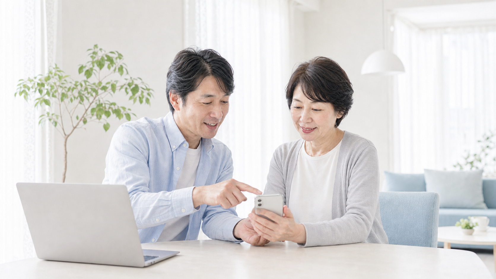 同じ相談スペースでスマートフォンの乗り換え手順を確認する担当者と日本人女性